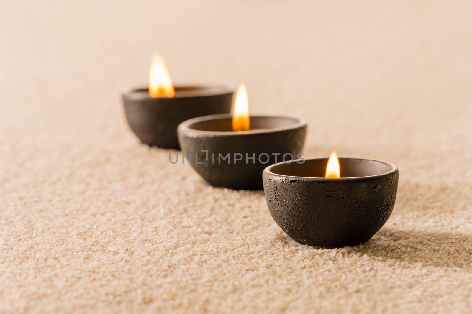 Spa therapy three candles on sand still nature