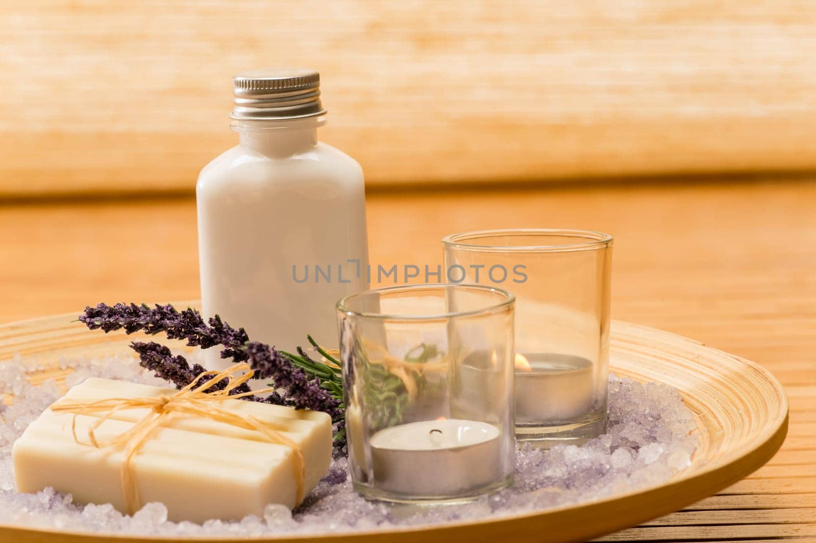 Aromatherapy lavender cosmetic products with candles on wooden tray
