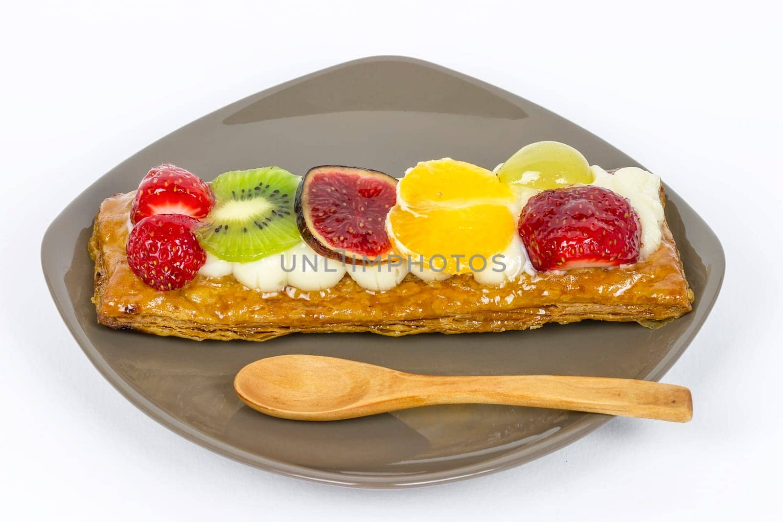Pastry and cream dessert with strawberries, kiwi, grapes, figs