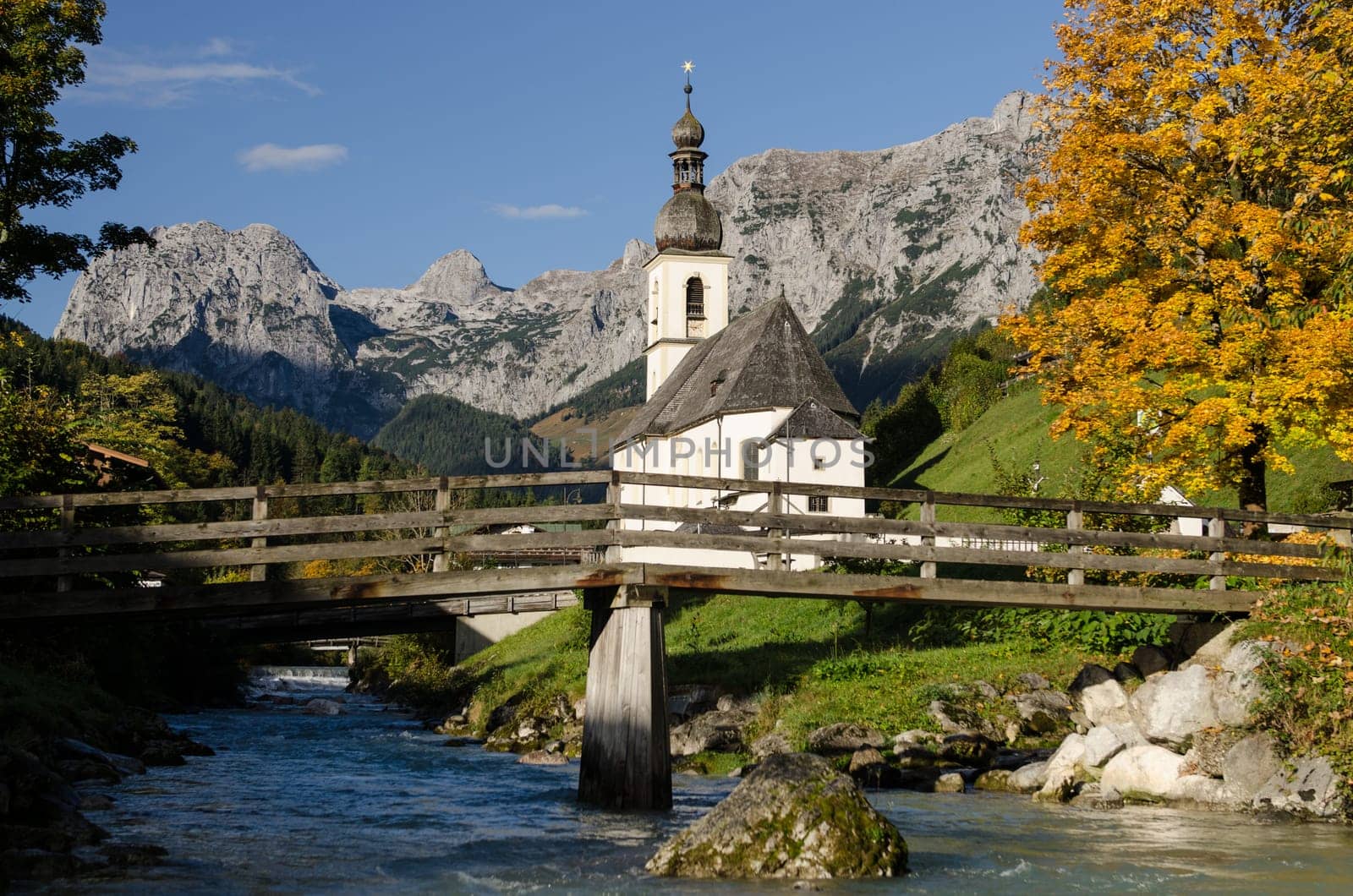 Church in Ramsau with stream and wooden bridge