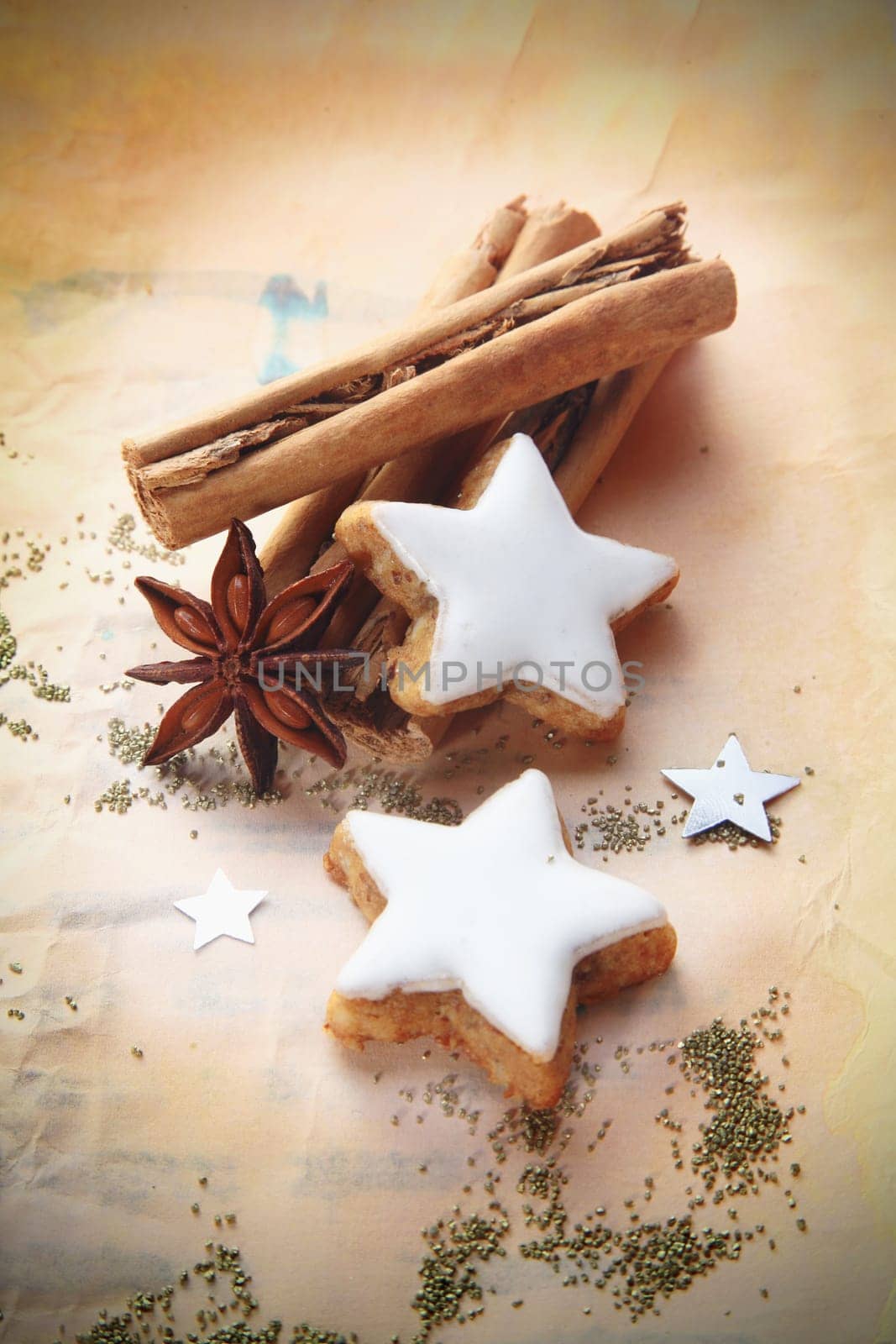 Christmas cinnamon and star anise spice with decorative whited iced star biscuits on vintage paper with vignetting