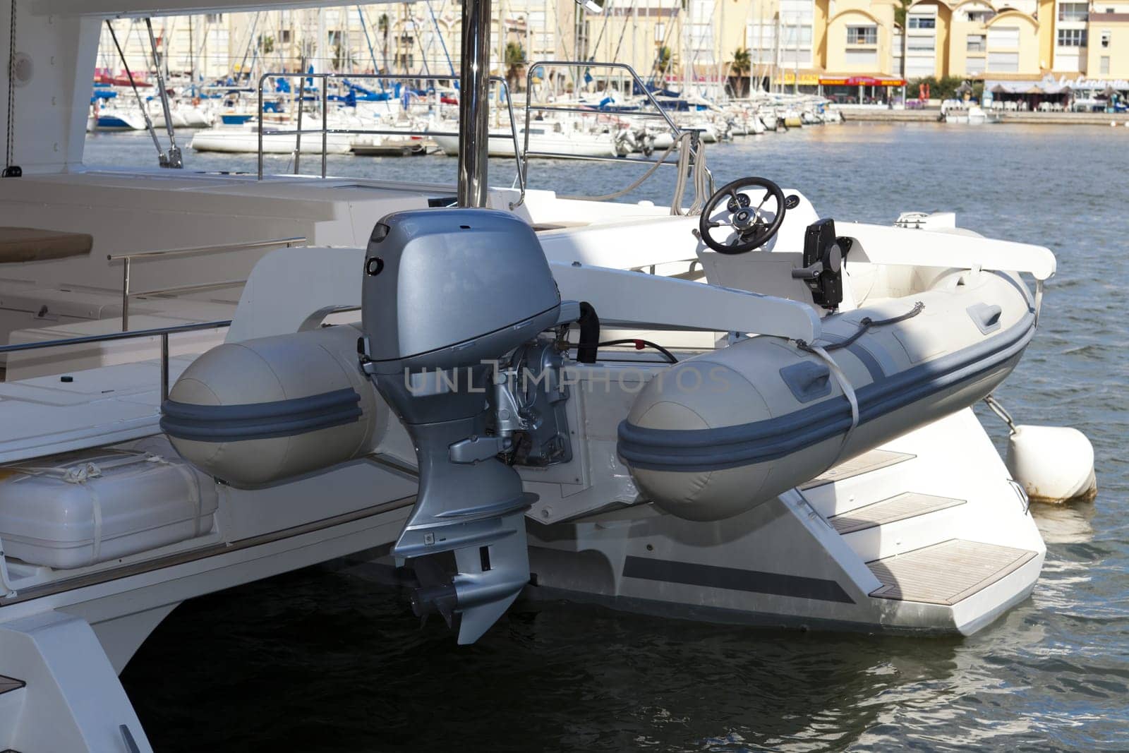 Dinghy with outboard engine on a catamaran sailing yacht in the port of Gruissan in the south of France