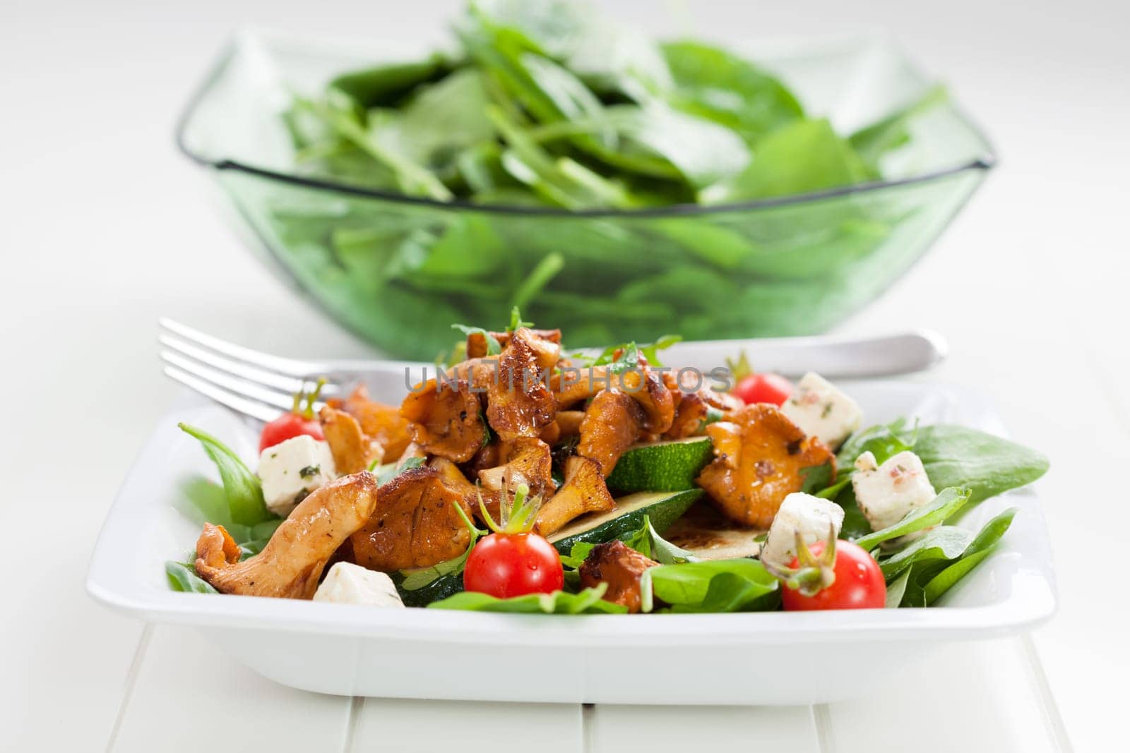Spinach salad with roasted chanterelle mushrooms on grilled zucchini