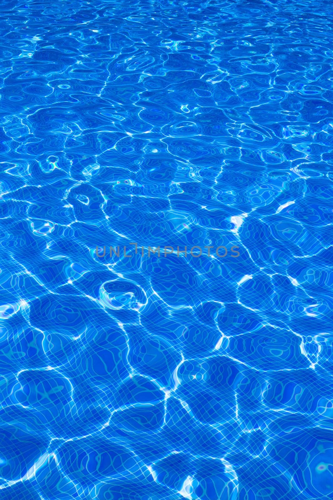 Blue tiles pool with ripple water reflection as a summer background