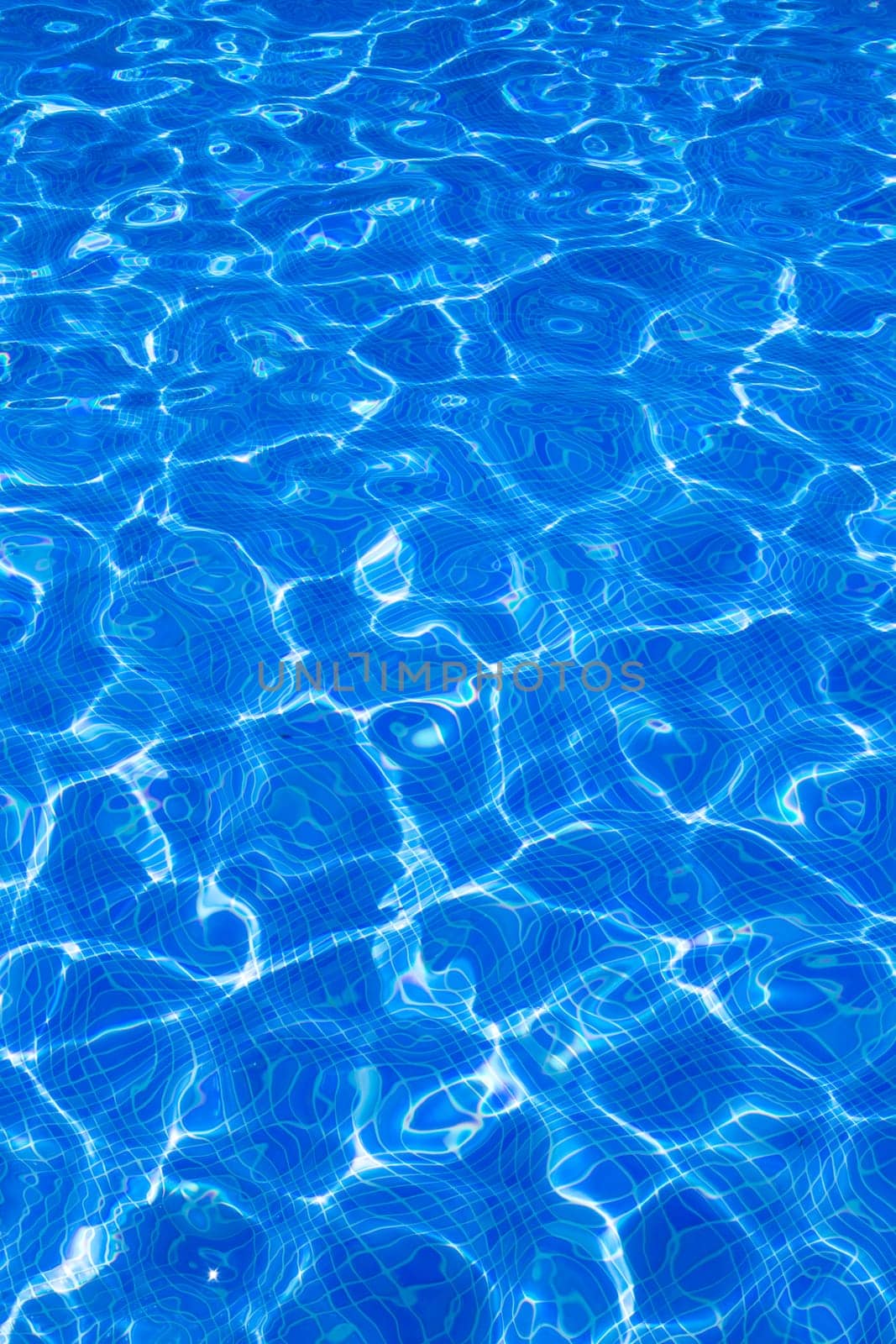 Blue tiles pool with ripple water reflection as a summer background