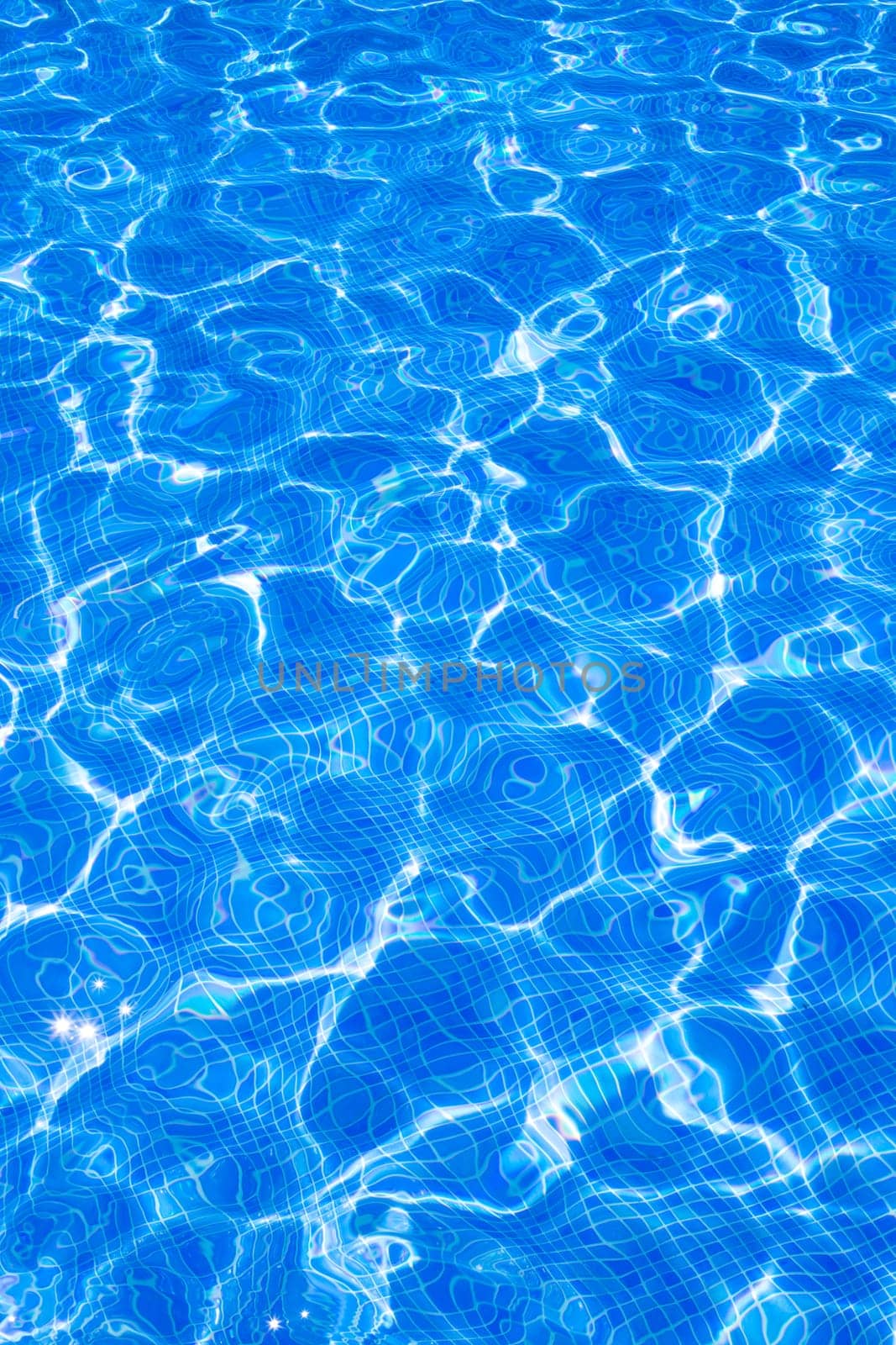 Blue tiles pool with ripple water reflection as a summer background
