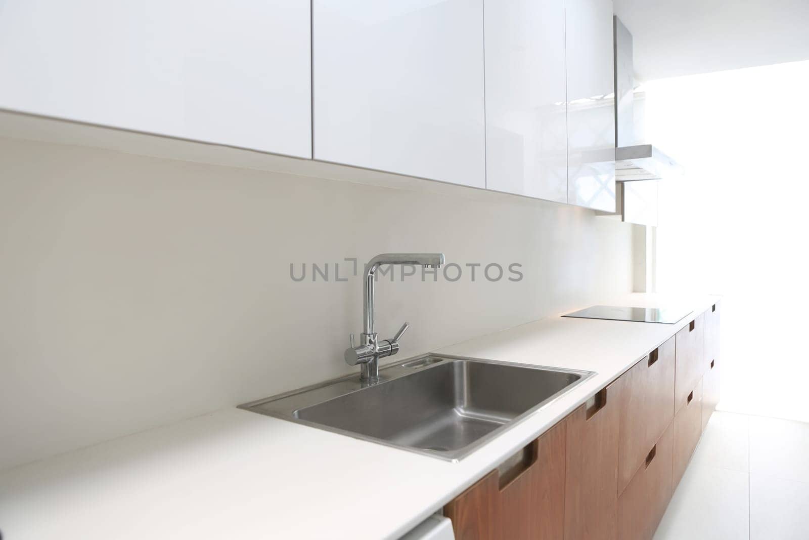 Actual modern kitchen in white and walnut wood interior house
