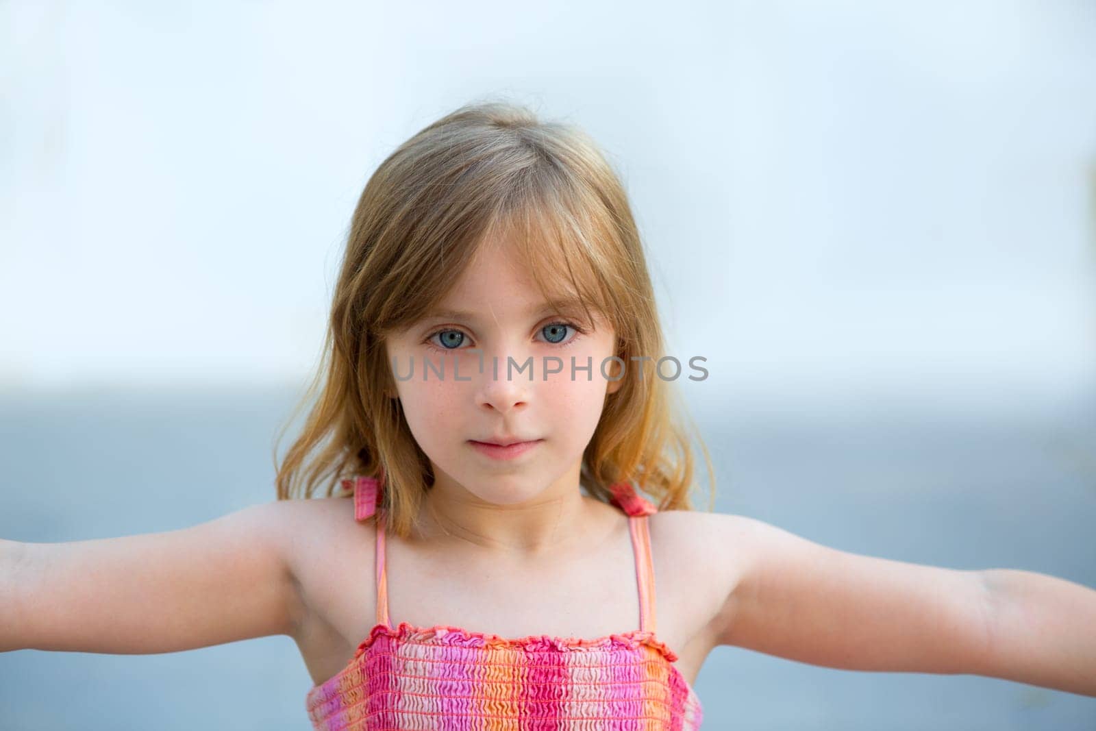Blond kid girl open arms in outdoor with sundress