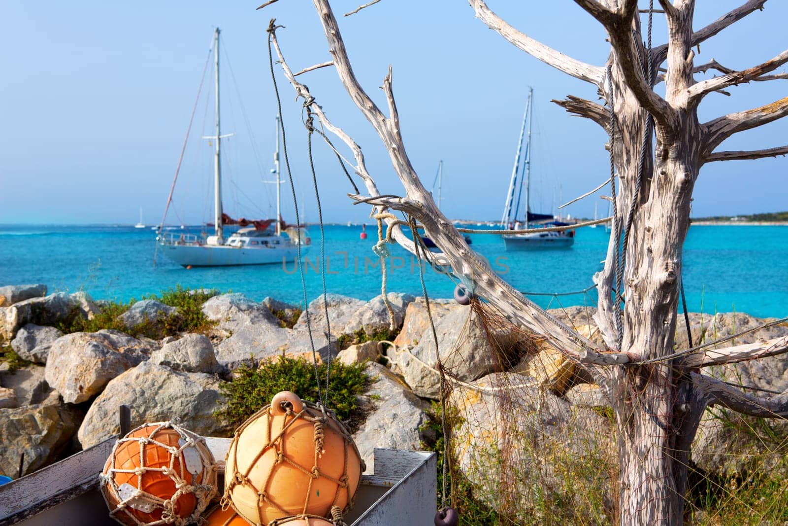 Aqua mediterranean in formentera with fishing buoys and sailboats