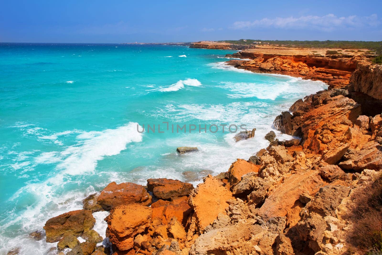 Cala Saona rocky coast with aqua turquoise rough Mediterranean sea