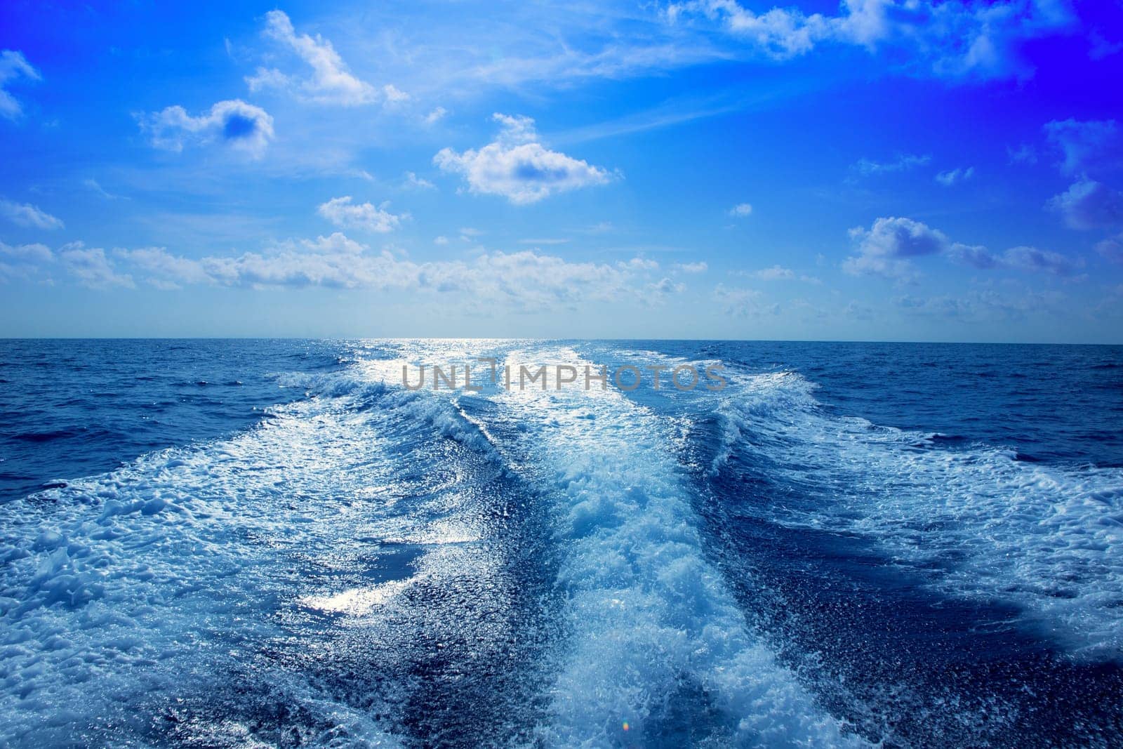 Boat wake speedy prop wash foam in blue sky at Mediterranean