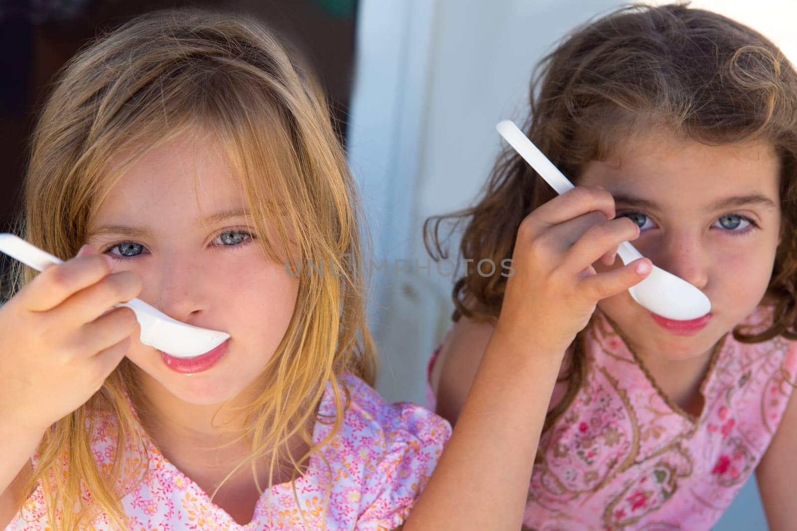 Blue eyes kids sister girl eating breakfast with spoon