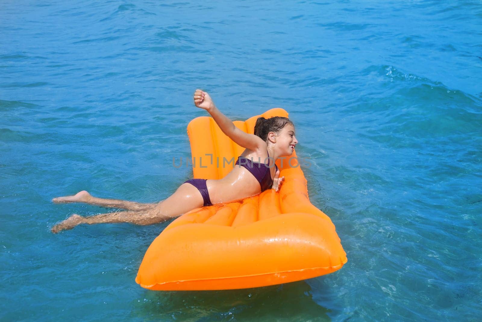 children kid girl playing in beach shore with orange floating lounge