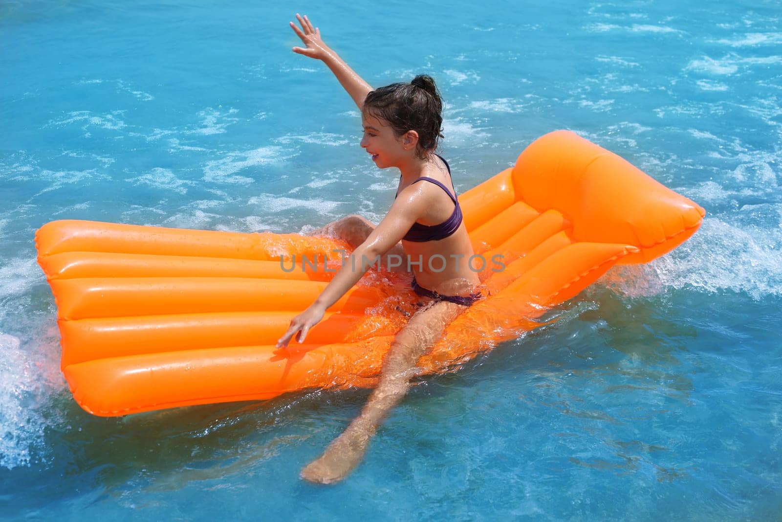 children kid girl playing in beach shore with orange floating lounge