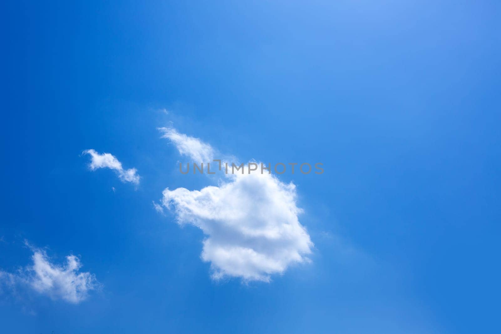 Blue sky with one cumulus and sunlight