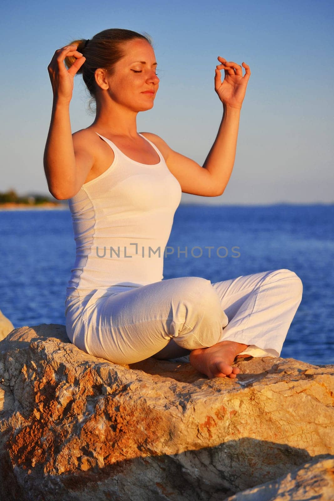 Young woman during yoga meditation on the beach