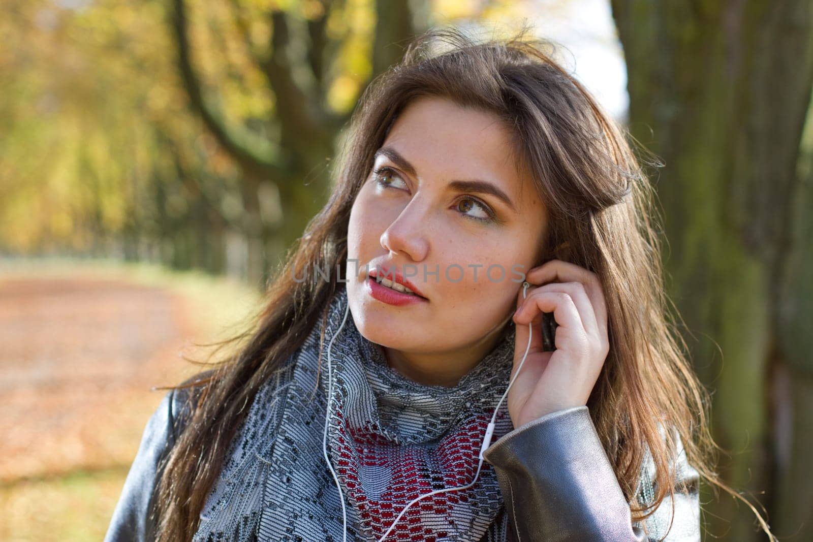 woman in park listening music in earphones