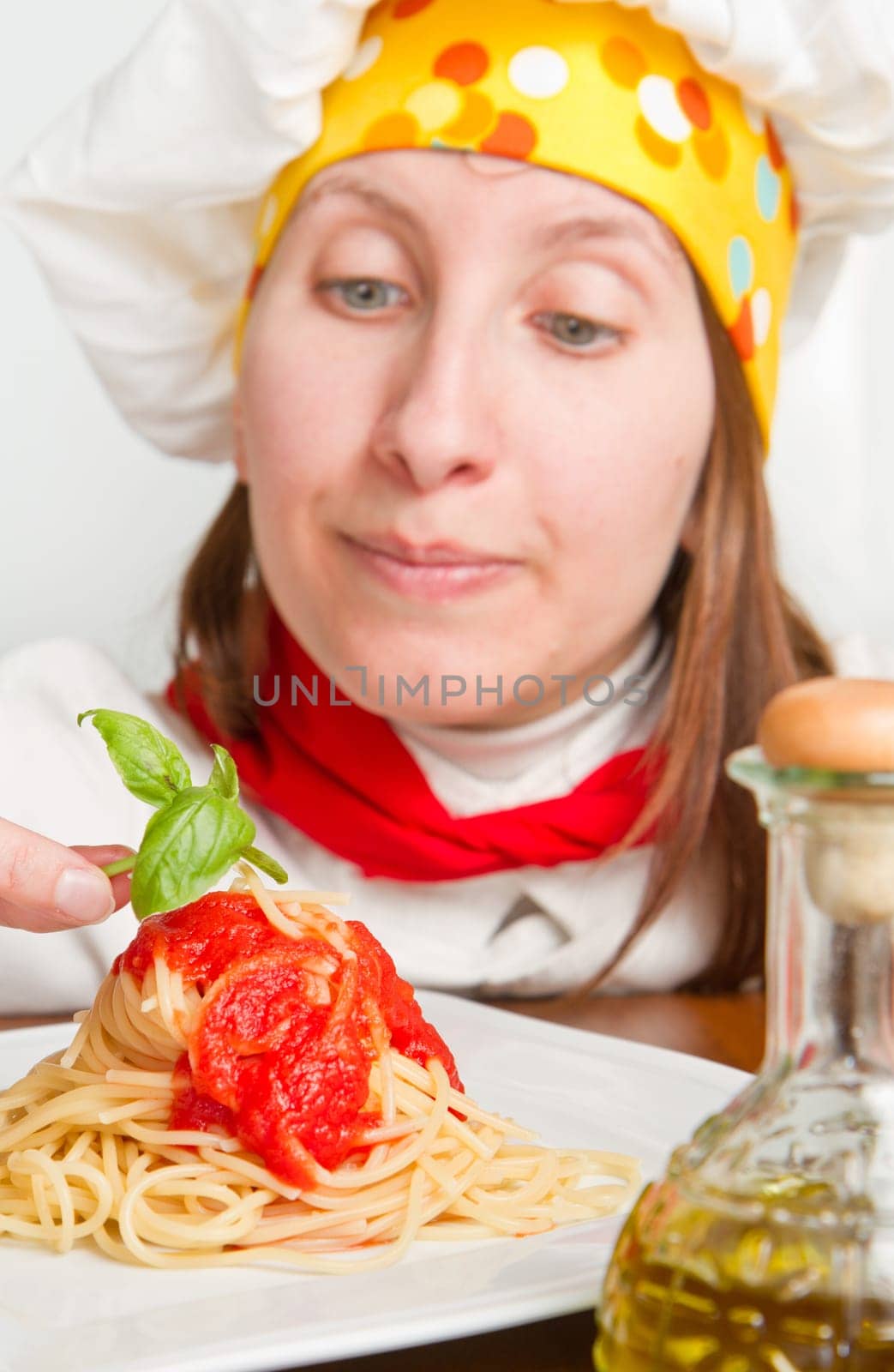 smiling chef garnish an Italian pasta dish