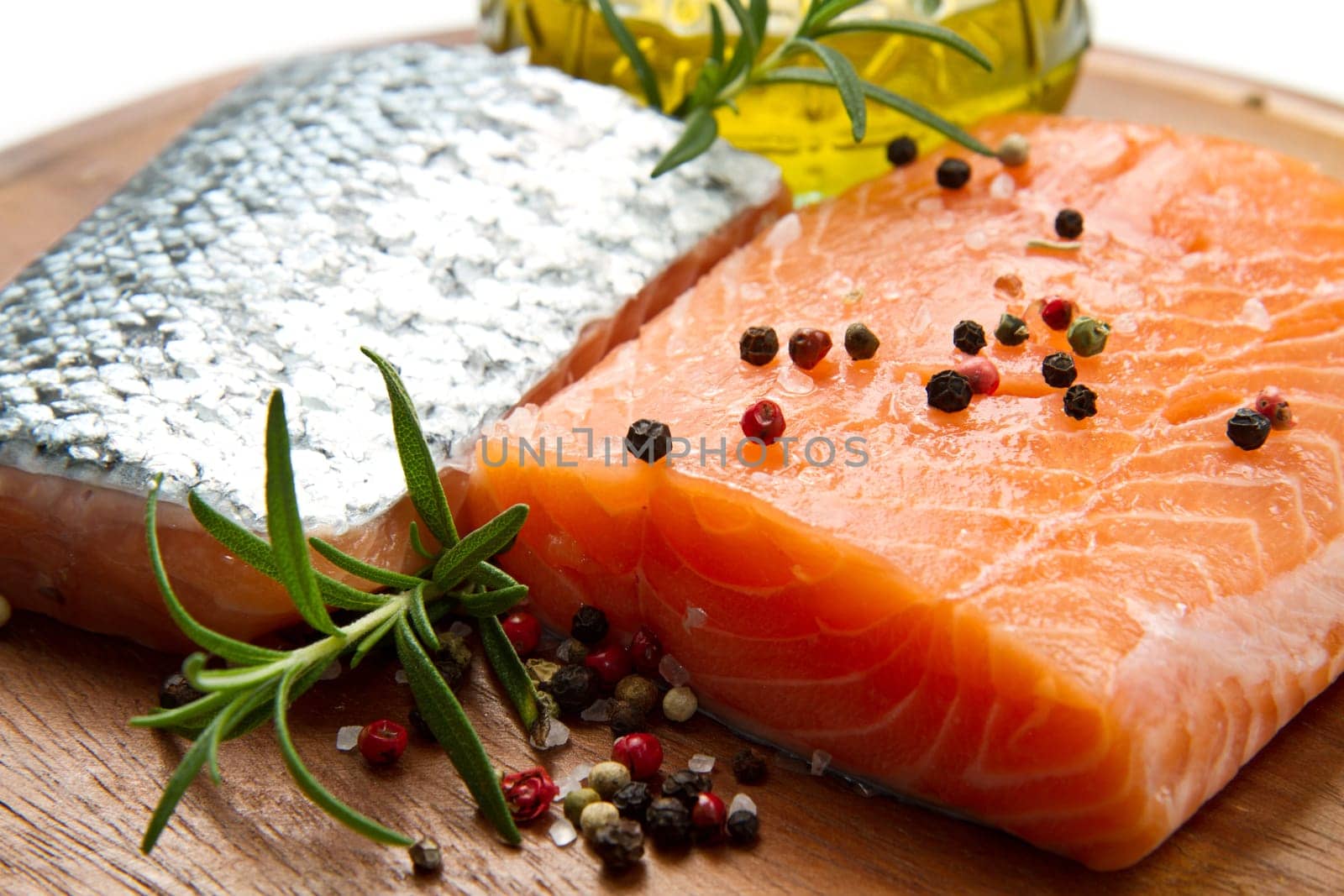 Fresh salmon fillet on wooden board with pepper and rosemary