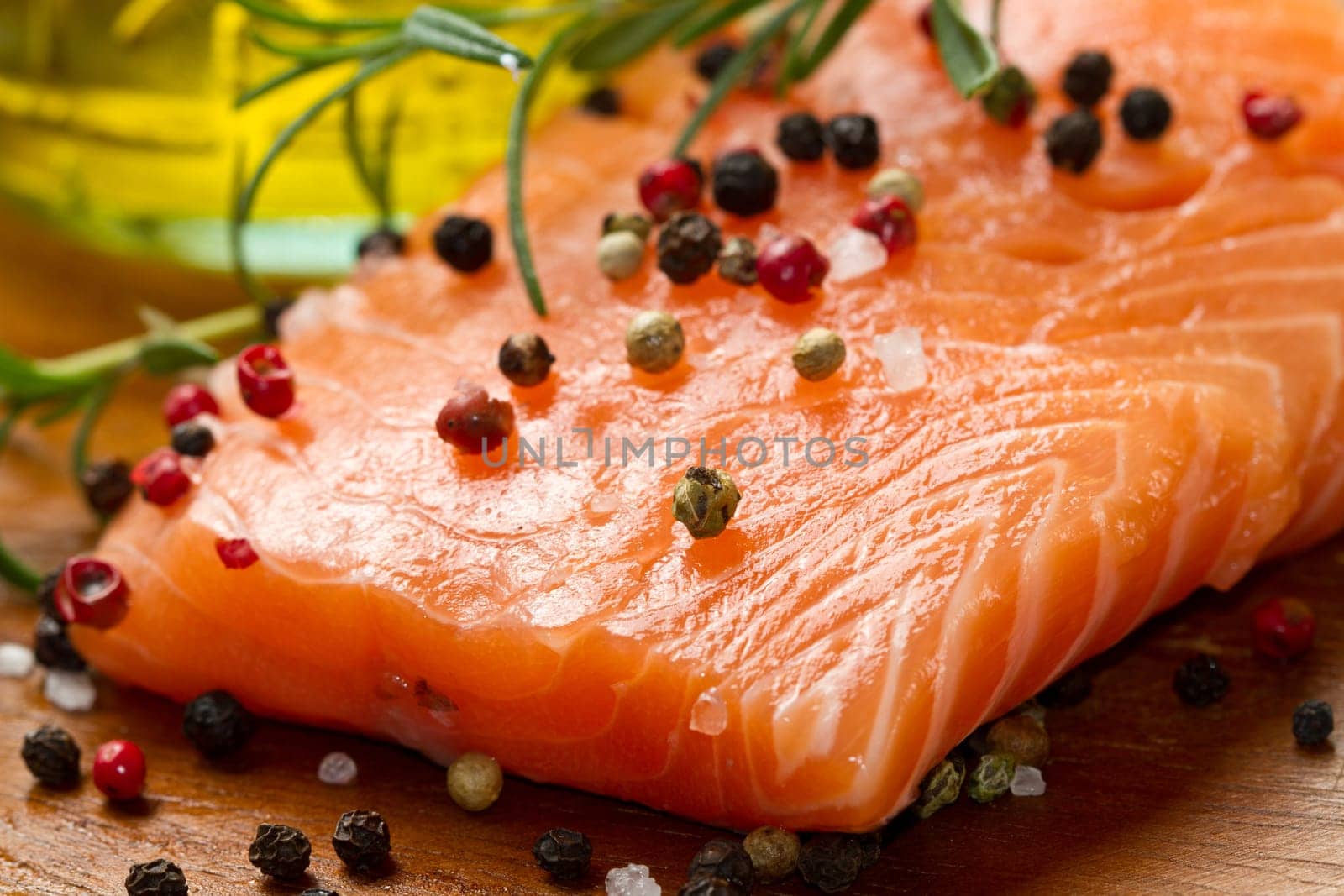 Fresh salmon fillet on wooden board with pepper and rosemary