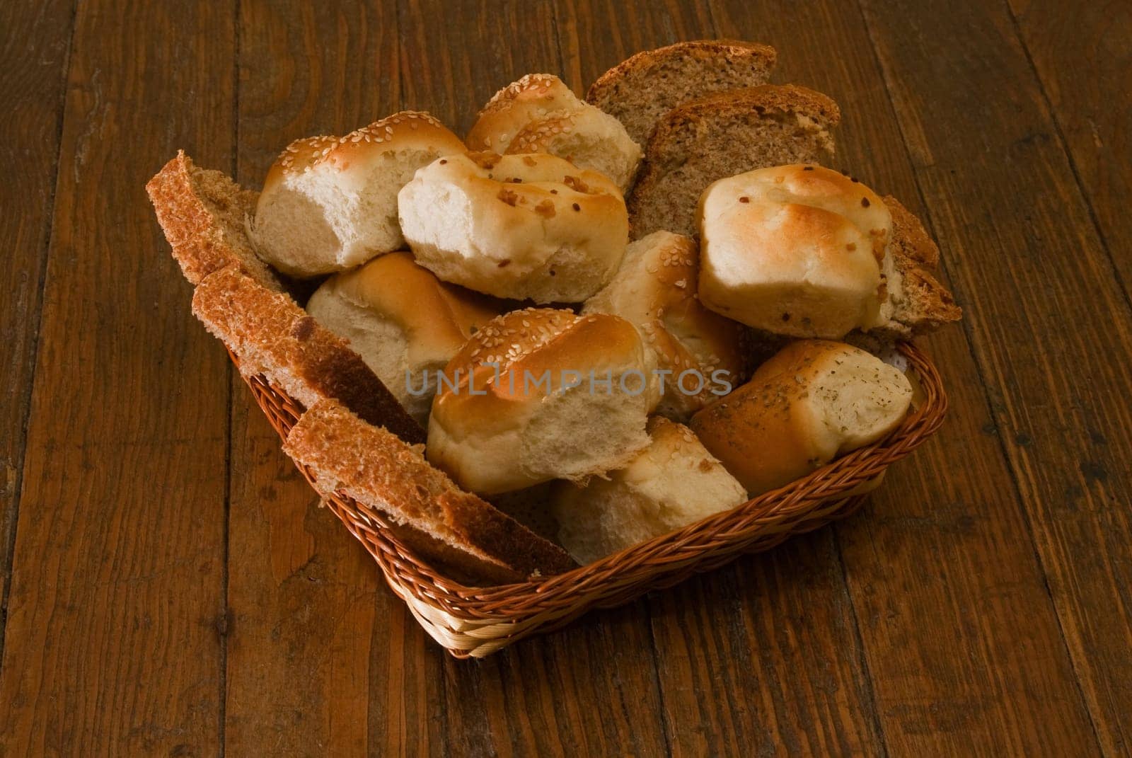 Fresh bread arrangement in basket on wooden table