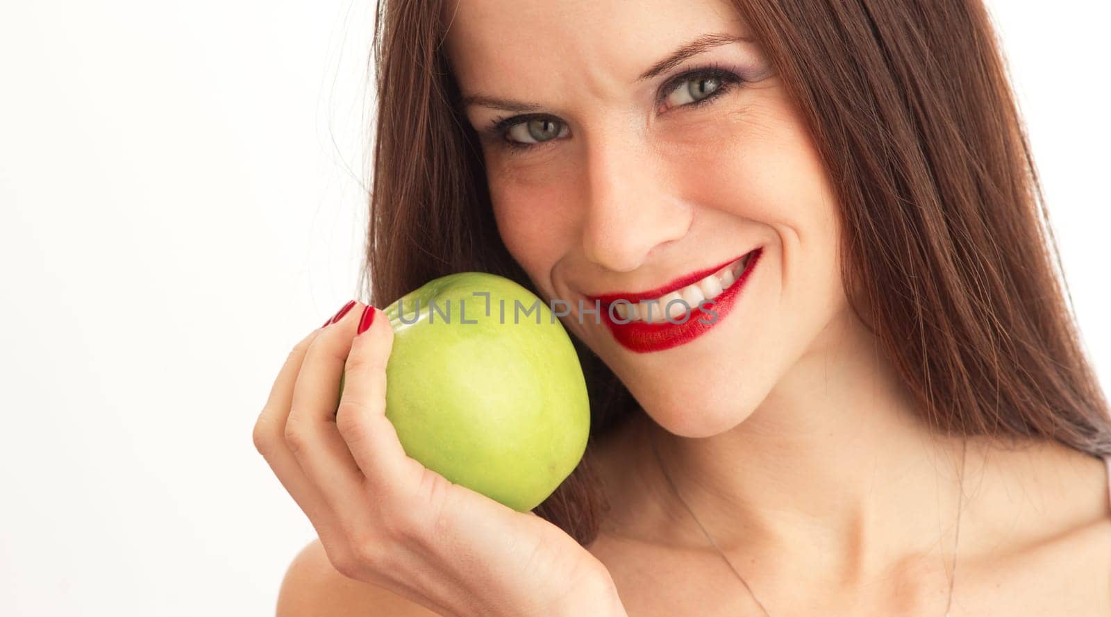 Stunningly beautiful young woman in a head and shoulders looks right at you holding an apple