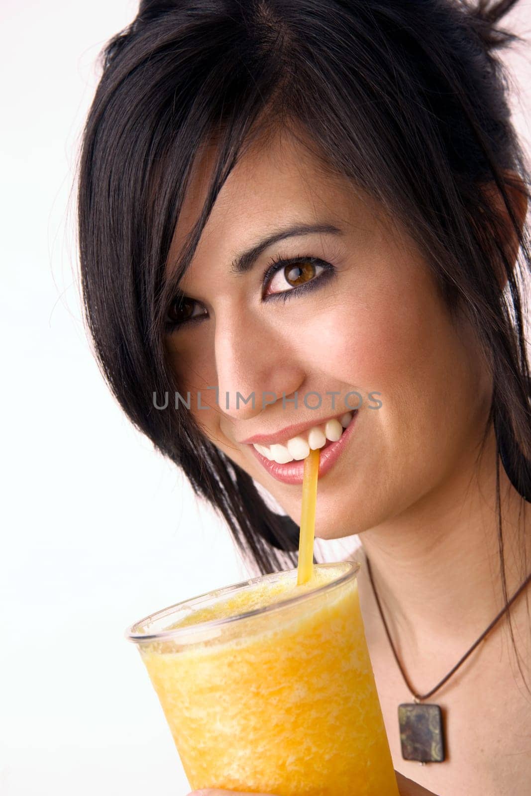 Attractive woman sips a yellow fruit smoothie through a straw