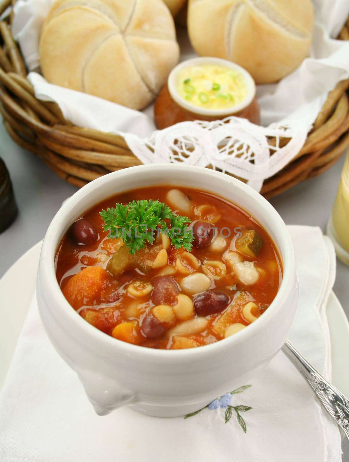 Delicious minestrone soup with fresh baked bread rolls and butter.