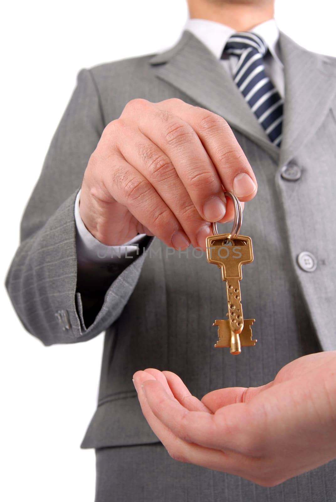 Businessman handing a key to success over a woman palm isolated on white.