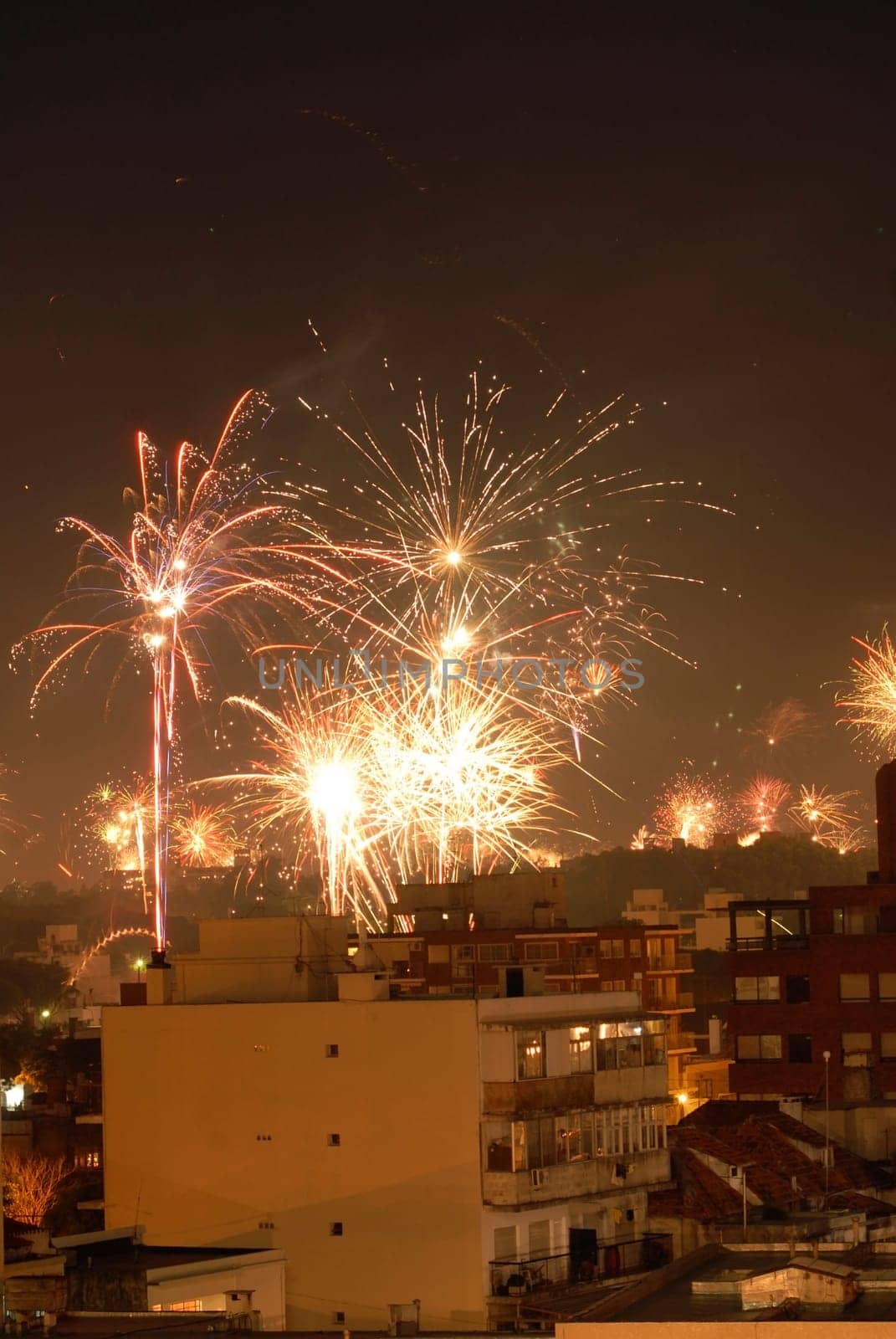 Beautiful new year fireworks celebration over the buildings. Montevideo, Uruguay