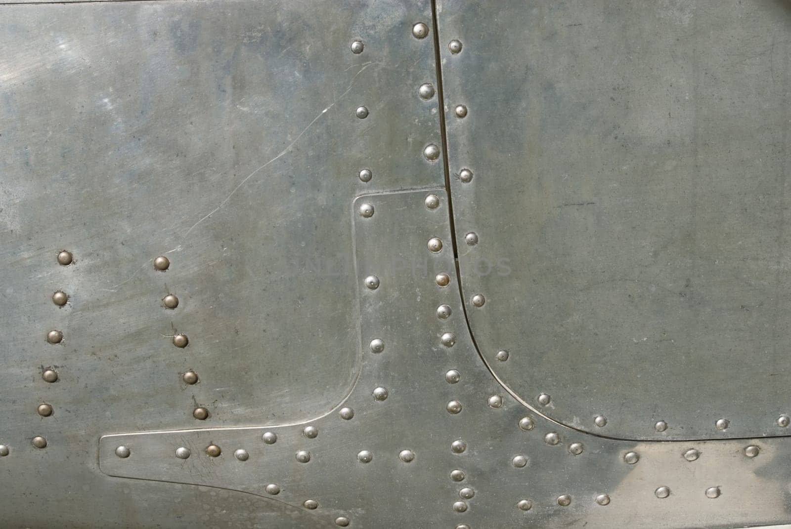 Airplane fuselage silvel metal texture with rivets. Useful as background for design works.
