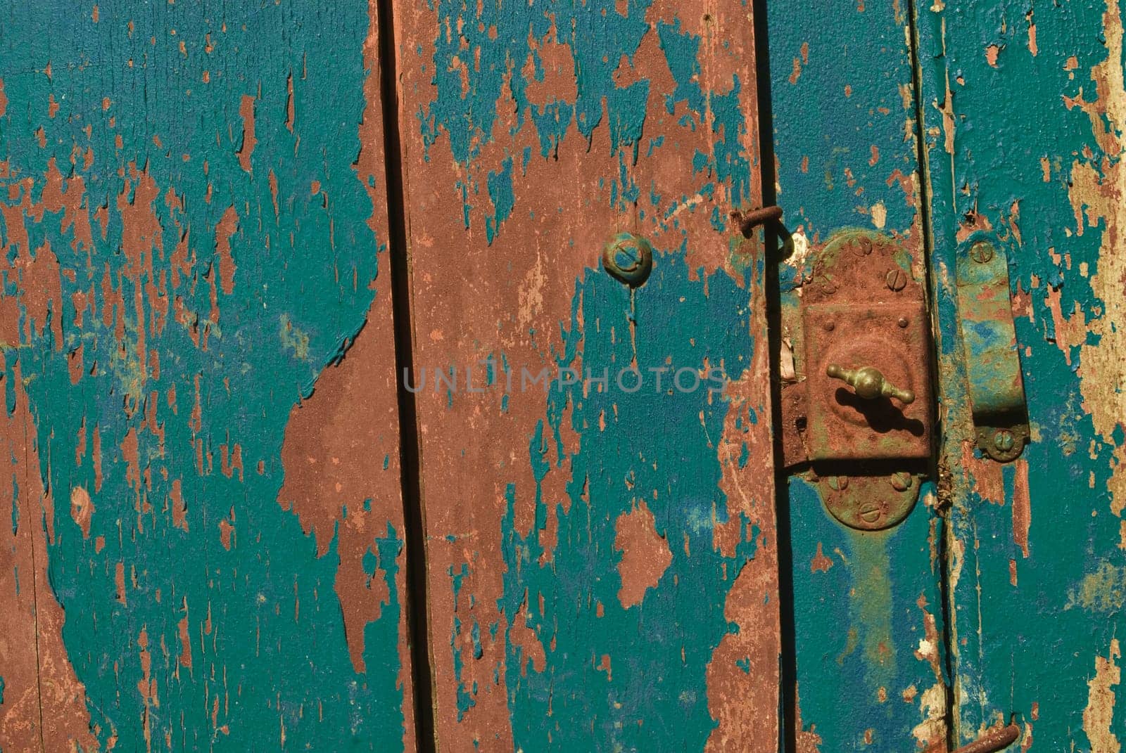 Vintage wooden door with the grunge lock and paint close up. Useful as background for design works.