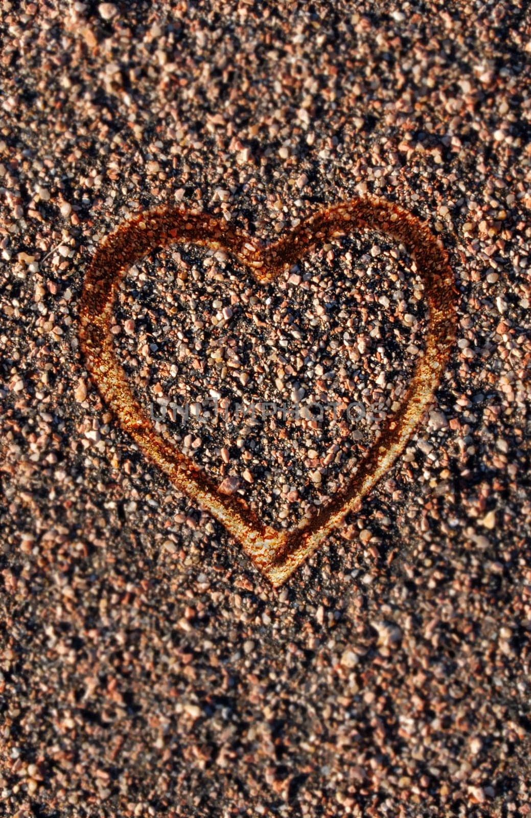 Heart contour on pebbles background.