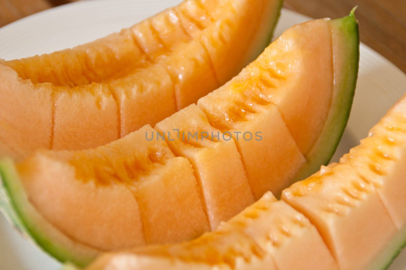 Yellow melon piece on a white plate.