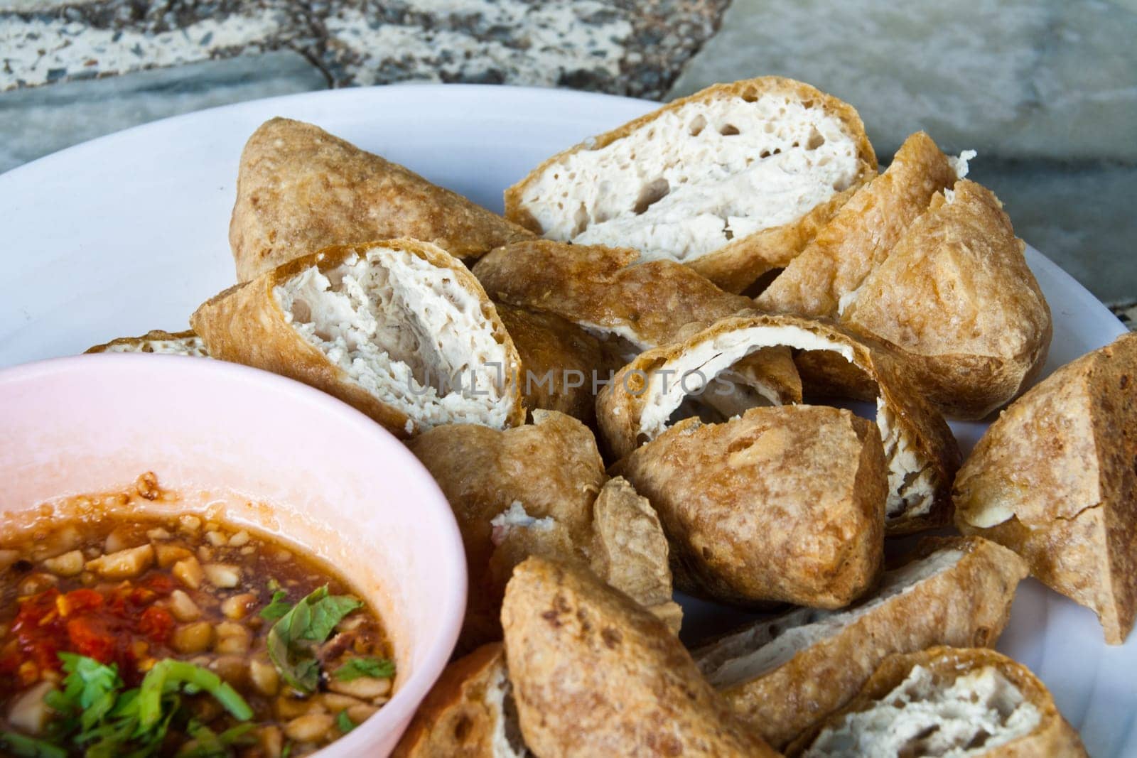 Fried tofu, cut into pieces with sauce.