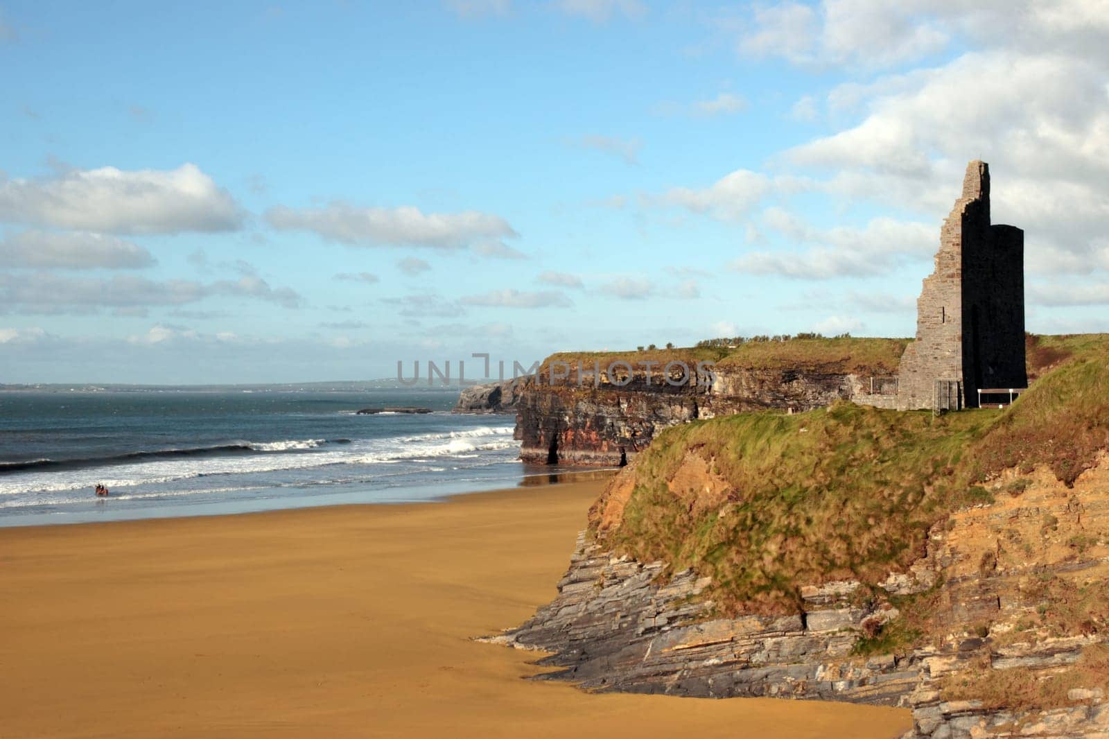 ballybunion castle on the cliffs in the west coast of ireland above a beautiful beach with horses