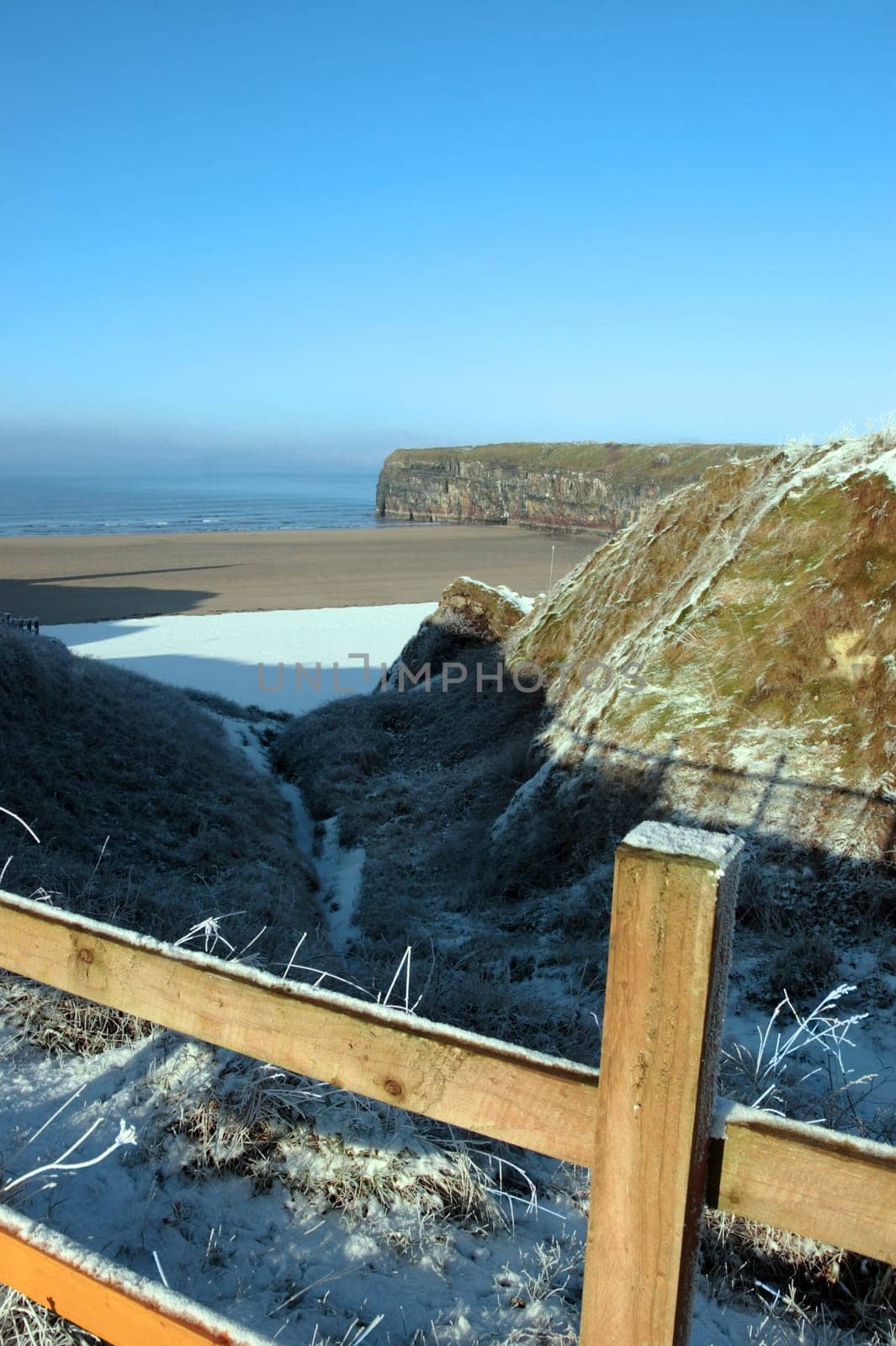 snow covered view of atlantic ocean and ballybunion beach and cliffs on a frosty snow covered winters day