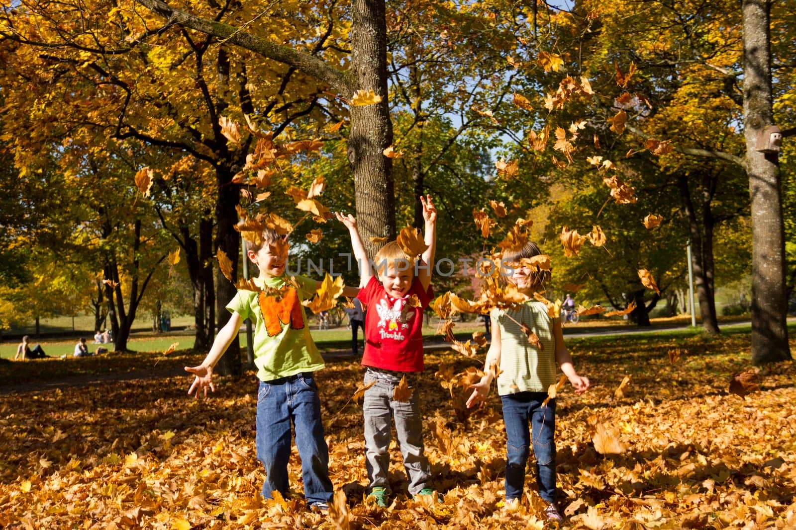 Children playing with leaves in autumn