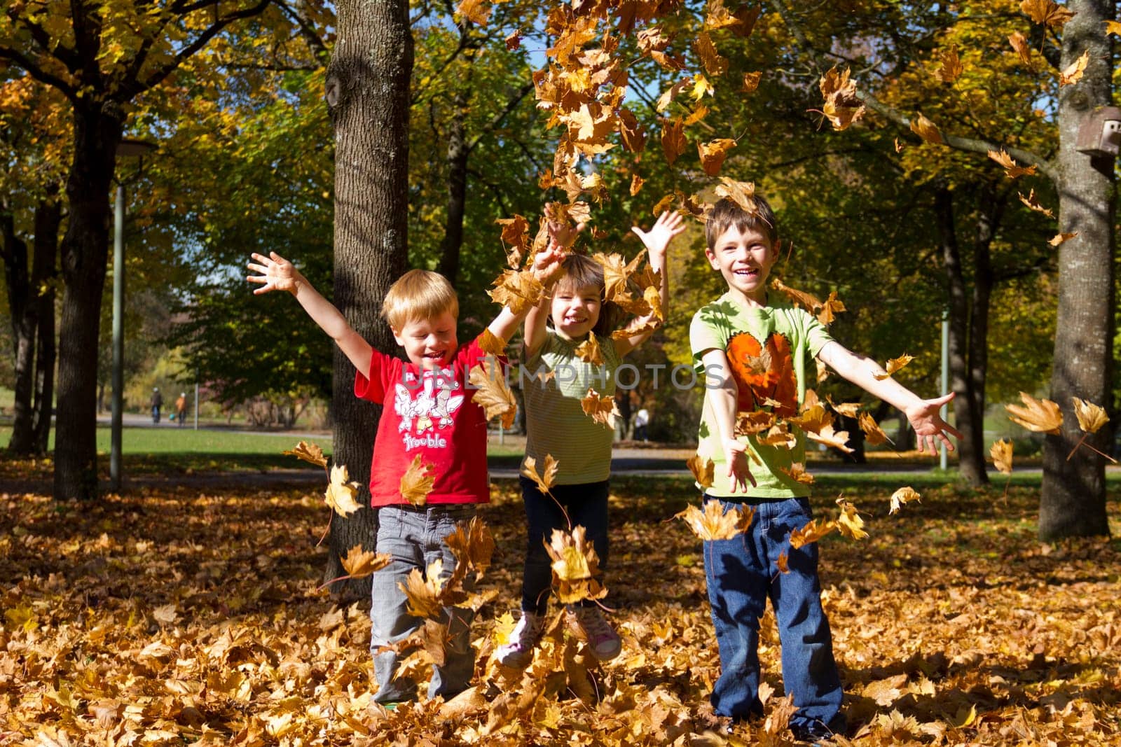 Children playing with leaves in autumn