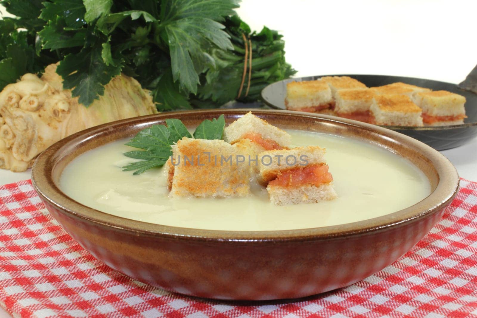 a bowl of cream of celery soup with salmon croutons