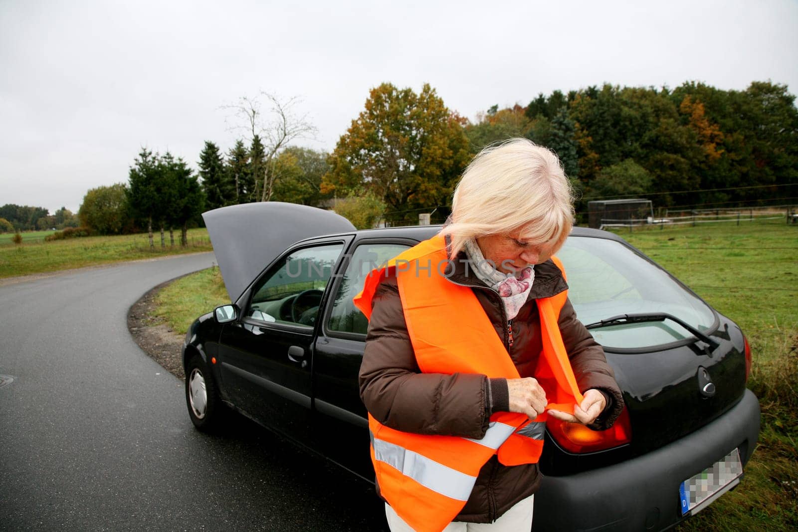Senior woman puts on traffic vest