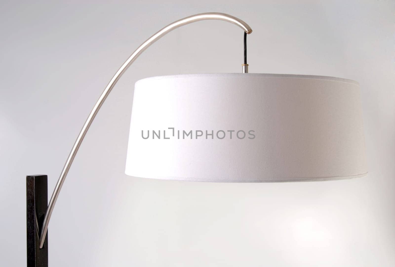 Metallic and wooden contemporary floor lamp detail. White lampshade. Isolated on white background
