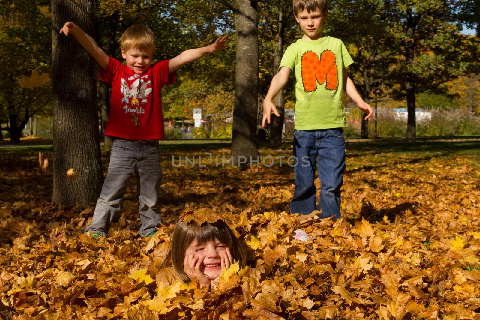 Children playing with leaves in autumn