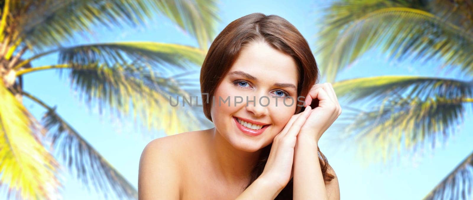 Beautiful brunette posing in front of the camera among tropical palms