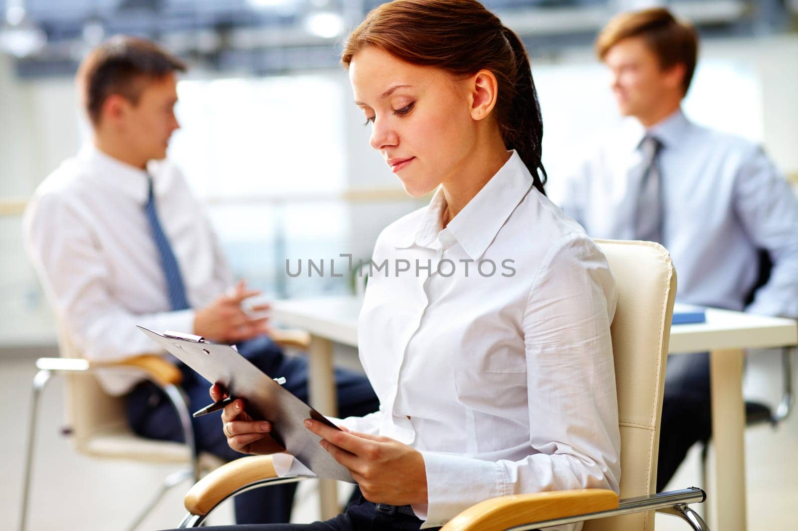 Image of a young beauty in the foreground on a usual office day