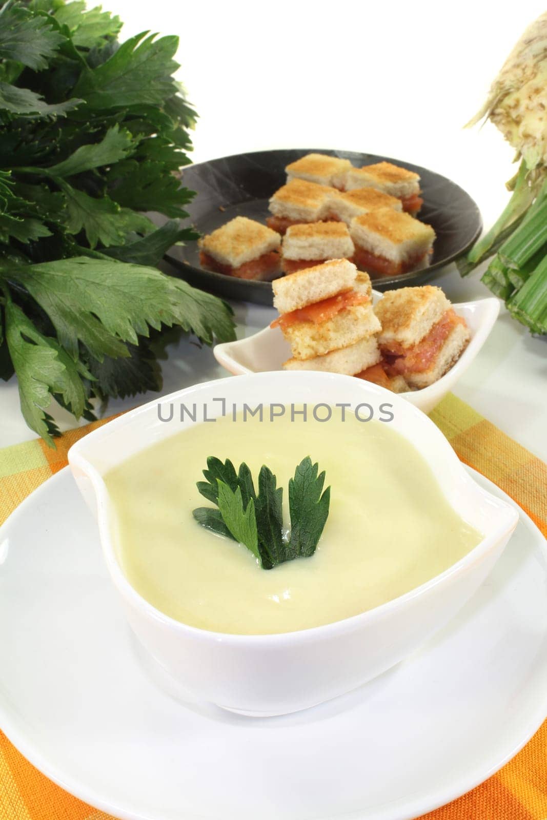 a bowl of cream of celery soup with salmon croutons