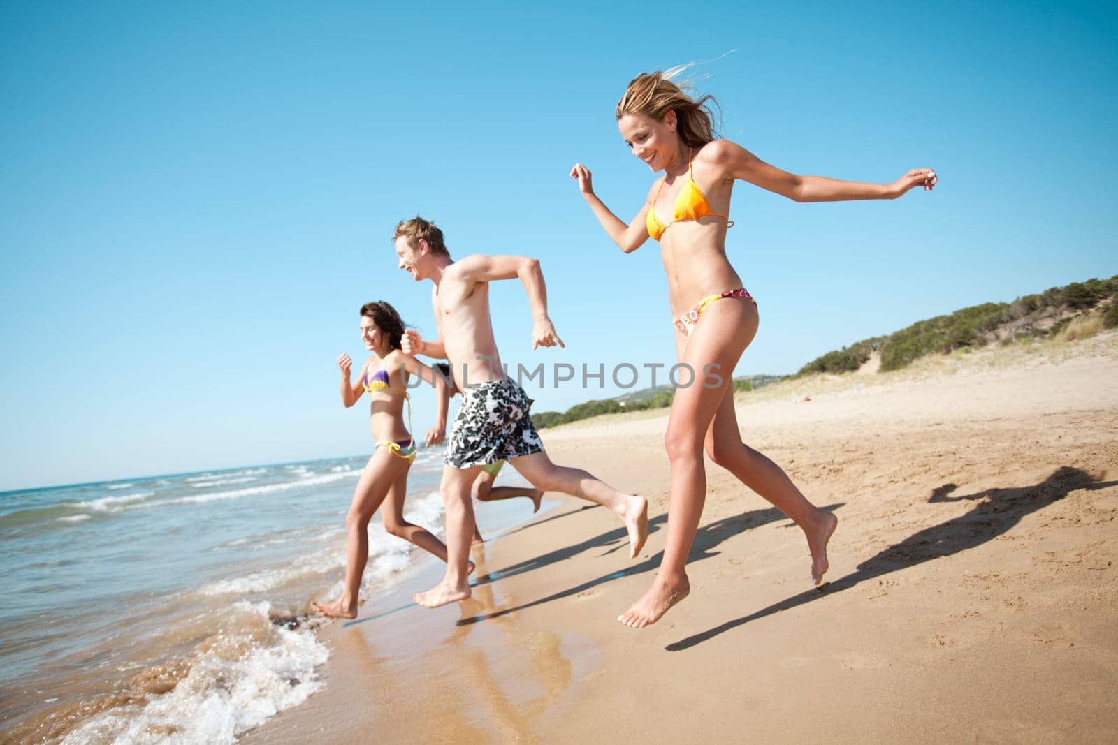 group of young people running into the sea, a little motion blur