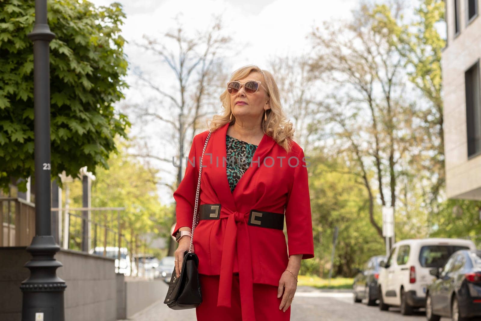Portrait Attractive Business Lady, Mature Sexagenarian Woman Walking in Street, City, Looking Away. Stylish Senior Female in her 60s Wears Sunglasses. Boss or Manager. Horizontal Plane by netatsi