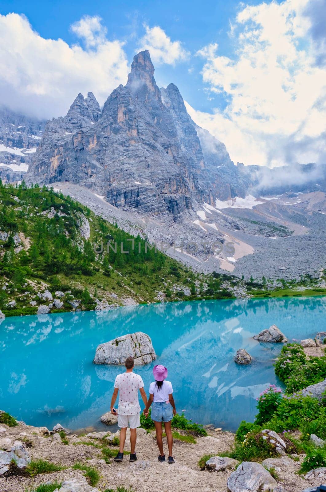 Lago di Sorapis in the Italian Dolomites, milky blue lake Lago di Sorapis, Lake Sorapis, Dolomites, Italy during summer, couple hiking in the Italian mountains of the Dolomites during summer holidays