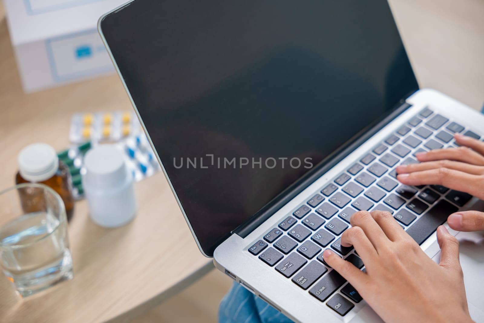 Sick young woman sit on sofa video call online with laptop consult with doctor at home, female covered blanket checking medications online, healthcare and technology